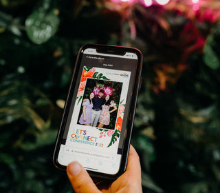 hand holding a phone with a photo booth photo displayed on the screen